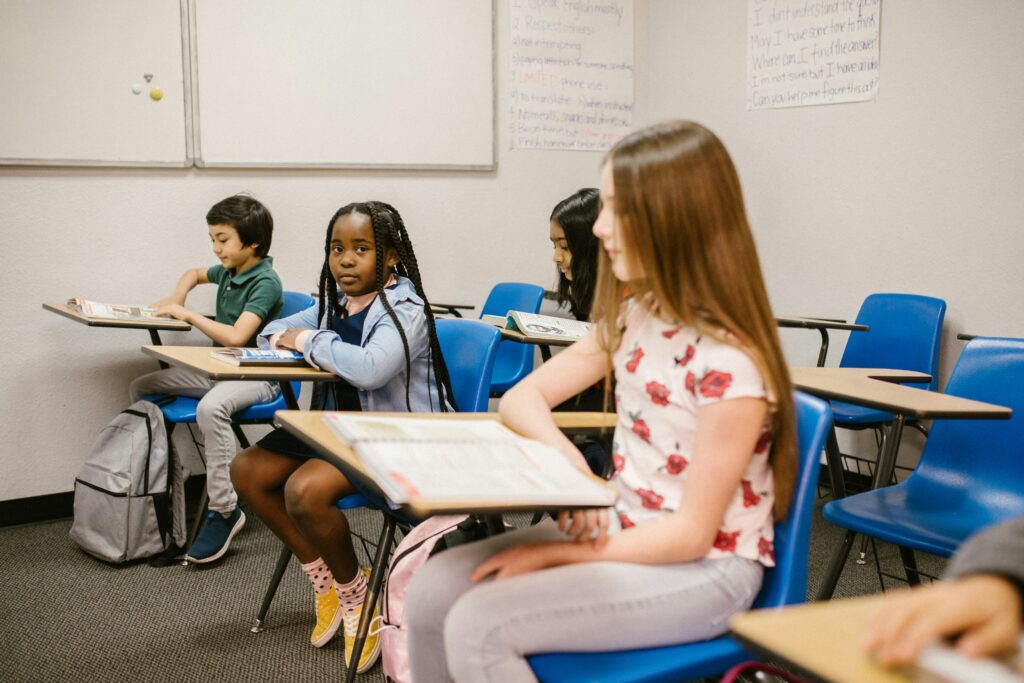 Children of diverse backgrounds sitting in a classroom, highlighting inclusivity and education.